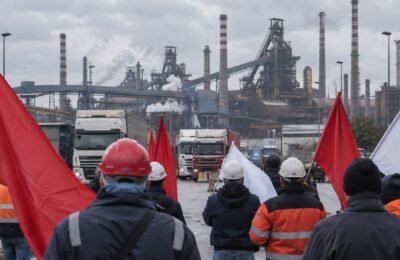 Работники с флагами у металлургического предприятия в Таранто